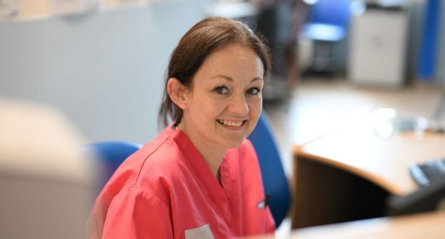 A midwife sat in the Birth Centre smiling to camera