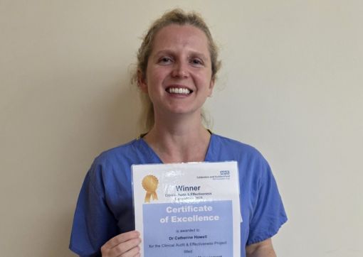 Catherine holding her certificate of excellence