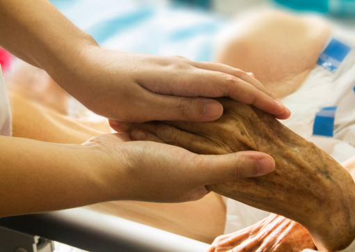 Image of female nurse holding the hand of a patient