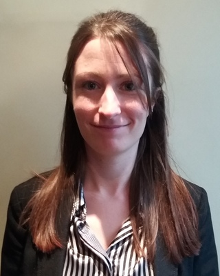 A person with long brown hair smiles for a picture.