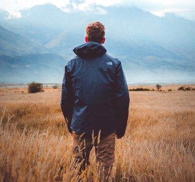 A person standing on a dry grass field