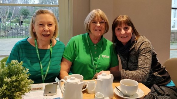 macmillan team and volunteers sat down drinking coffee