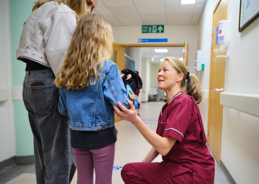 A photo of Radiographer Alison greeting Esme and mum Lauren