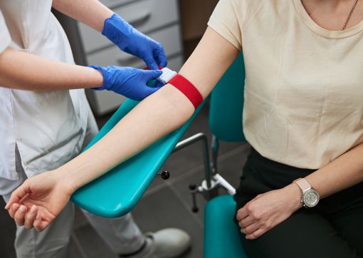 A person sat in a chair having a blood test
