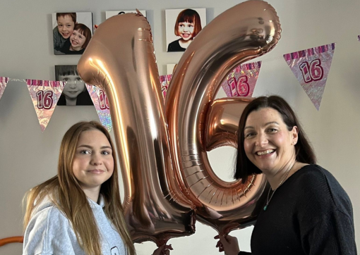 Image of Ava and her mum holding pink helium balloons in the shape of a 16
