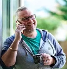 Man talking on phone with a cup in hand