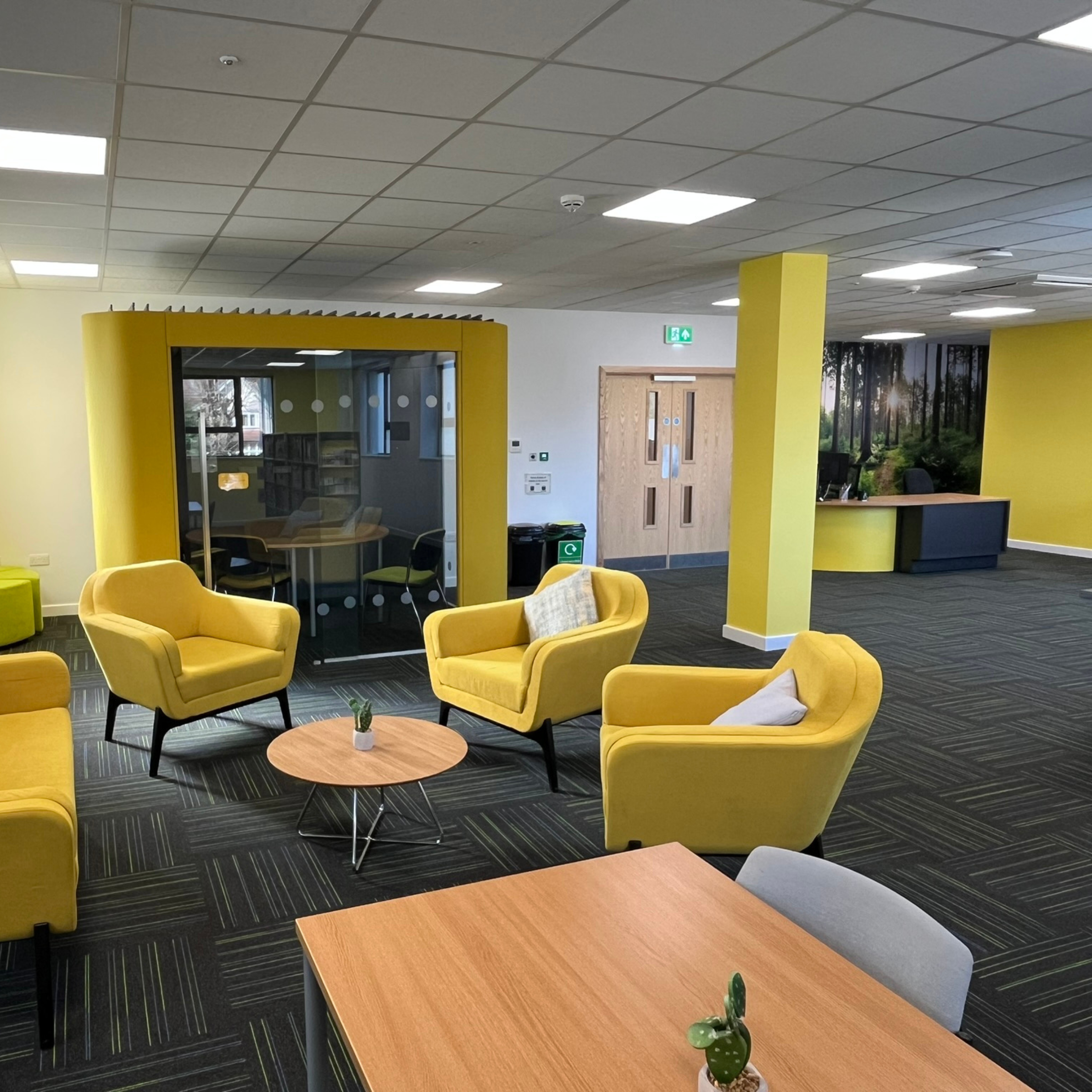 A photo of the social space, study pod and front desk in the library.