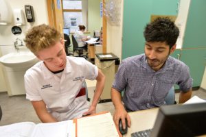 An image of a young male shadowing on of our staff members