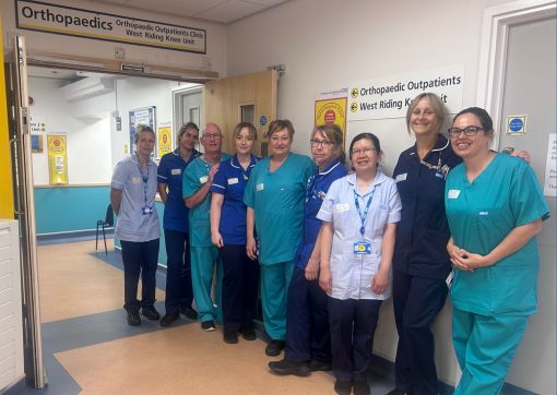 A photo of the Orthopaedic Outpatient team outside the entrance to the department at HRI